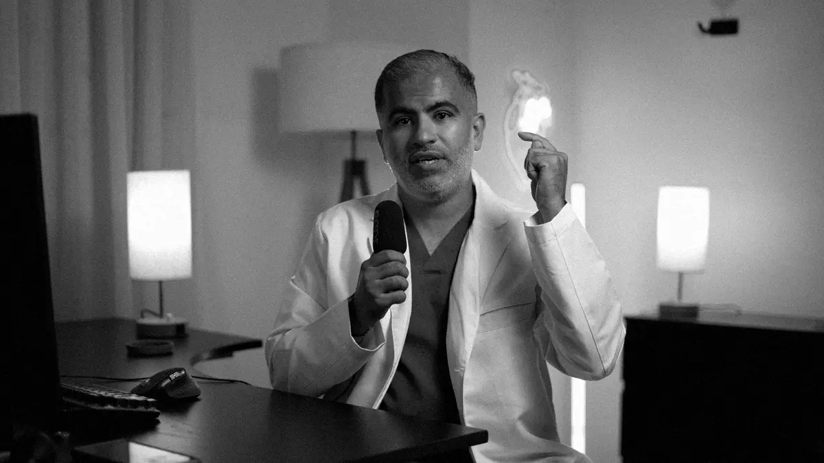 د. محمود العقيلي يشرح أمام الكاميرا في الاستوديو، بالأبيض والأسود